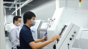 Рабочие управляют производственным оборудованием на предприятии ICT Vina в Высокотехнологичном парке города Дананг. (Иллюстративное фото: ВИА)