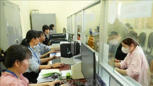 Государственные служащие в коммуне Тхайми (город Хошимин) рассматривают административные документы для граждан. (Фото: ВИА)