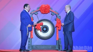 Премьер-министр Фам Минь Тьинь и руководитель Шанхайской фондовой биржи проводят церемонию удара в гонг. Фото: Тхань Жанг