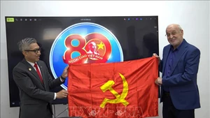 Посол Вьетнама в Израиле Ли Дык Чунг вручает знамя КПВ товарищу Иссаму Махулу. Фото: ВИА