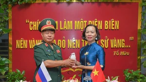 Генерал-майор Лыу Чонг Лы передает урну с землёй директору Музея Победы Дьенбьенфу Ву Тхи Тует Нга. Фото: ВИА