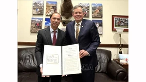 Сенатор США Стив Дэйнс вручает Послу Вьетнама в США Нгуен Куок Зунг резолюцию Сената США, посвященную 30-летию нормализации отношений между США и Вьетнамом. Фото: ВИА 
