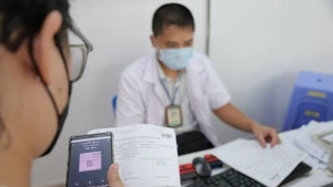 Пациент оплачивает больничные услуги с использованием безналичных расчётов. Фото: qdnd.vn