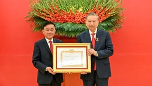 Постоянный член Секретариата Чан Кам Ту вручает знак «45 лет членства в Партии» Генеральному секретарю ЦК КПВ То Ламу. Фото: Зюи Линь