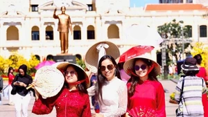 Вьетнамцы за рубежом в традиционных аозай прогуливаются по Цветочной улице Нгуен Хюэ. Фото: qdnd.vn