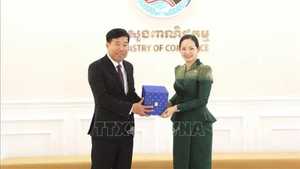 Заместитель министра иностранных дел Нгуен Мань Кыонг и Министр торговли Камбоджи Чам Нимул обмениваются памятными подарками. Фото: ВИА