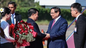 Должностные лица Лаоса приветствуют Премьер-министра Фам Минь Тьиня. Фото: VGP