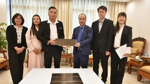 Председатель Государственного комитета по делам вьетнамцев, проживающих за границей, Нгуен Чунг Киен вручает бронзовую мемориальную доску представителю сообщества вьетнамцев в Вануату До Ван Зы. 