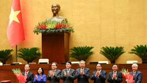 Руководители Партии и Государства вручают цветы Заместителю председателя НС До Ван Тьиену и Председателю Верховного народного суда Нгуен Ван Куангу. Фото: Зюи Линь