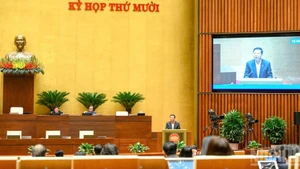 Министр строительства Чан Хонг Минь разъясняет ряд вопросов, поднятых депутатами НС на заседании во второй половине дня 28 ноября. Фото: Зюи Линь