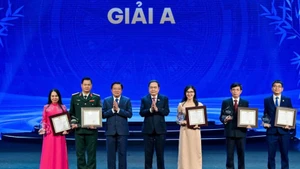 Председатель НС Чан Тхань Ман и Заведующий Отделом ЦК КПВ по внутренним делам Фан Динь Чак вручают призы А авторам и группам авторов. Фото: Тхюи Нгуен
