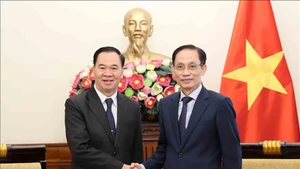 Министр иностранных дел Ле Хоай Чунг (справа) и Министр образования и спорта Лаоса Тхонгсалит Мангномек. Фото: ВИА