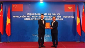 Генерал-лейтенант Фам Данг Кхоа вручает памятный подарок товарищу Лю Цзе, заместителю начальника Департамента управления и контроля пограничной службы Государственного управления по делам иммиграции КНР, глава китайской делегации. Фото: cand.com.vn