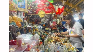 Иностранные туристы выбирают изделия ручной работы и художественные ремесленные товары в качестве сувениров во время посещения города Хошимина. Фото: ВИА