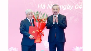 Генеральный секретарь ЦК КПВ То Лам вручает Решение Политбюро о распределении и назначении товарища До Ван Тьена на должность постоянного заместителя секретаря партийного комитета Национального собрания. Фото: ВИА