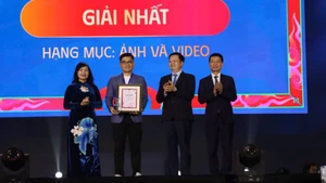 Вице-премьер Май Ван Тьинь вручает первый приз в категории «Фото» автору Фам Нгок Лонг Тхиену. 