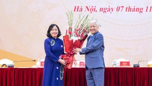 Постоянный замсекретаря Парткома НС, бывший Председатель ЦК ОФВ До Ван Тьиен вручает цветы с поздравлением товарищу Буй Тхи Минь Хоай.