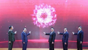 Постоянный член Секретариата ЦК Чан Кам Ту вместе с делегатами торжественно запускает мобильное приложение отрасли пропаганды и работы с населением. Фото: ВИА