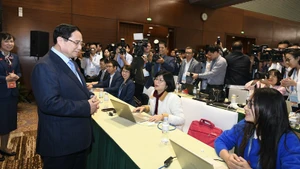 Премьер-министр Фам Минь Тьинь посещает пресс-центр XIV съезда КПВ. Фото: Зюи Линь