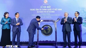 Премьер-министр Фам Минь Тьинь бьёт в гонг, открывая МФЦ в Хошимине. Фото: ВИА