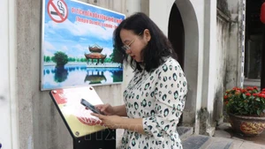 Турист сканирует QR-код, чтобы получить доступ к цифровому экскурсионному маршруту в историческом комплексе храма До. Фото: ВИА