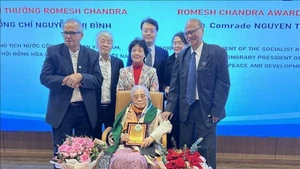 Представители AIPSO вручает премию Ромеша Чандры г-же Нгуен Тхи Бинь. Фото: ВИА