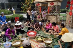 Жители жилого комплекса «Анфу» (город Тхудык) вместе заворачивают баньчынг, готовясь к празднованию Тэта. (Фото: ВИА)