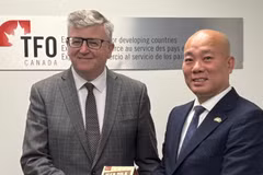 Руководители делегаций Vietrade и TFO Canada обмениваются памятными подарками после дискуссионной сессии. (Фото: ВИА)