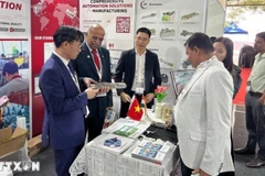 Торговый советник Посольства Вьетнама в Индии Буй Чунг Тхыонг (первый слева) и почетный консул Вьетнама в Бангалоре Н. Шриниваса Мурти посещают вьетнамский выставочный стенд. (Фото предоставлено Торговым представительством Вьетнама / ВИА)