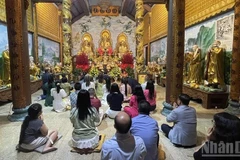 Представители вьетнамской общины в Лаосе с благоговением возносят молитвы о мирном и счастливом новом годе. (Фото: Зюи Тоан)