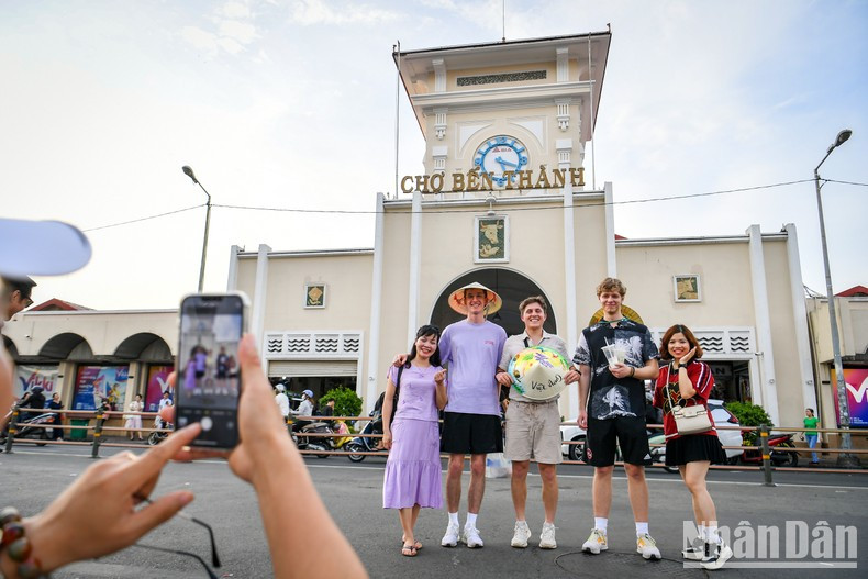 Туристы фотографируются у рынка Бентхань. Фото: Тхань Дат
