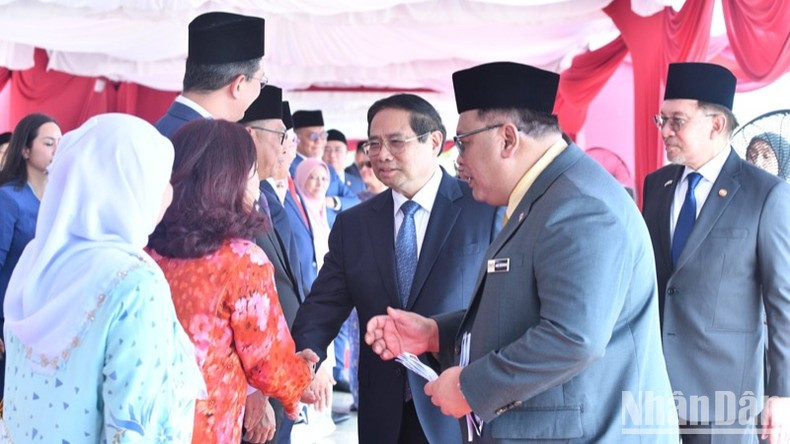 Премьер-министр Фам Минь Тьинь знакомится с малайзийскими официальными лицами на церемонии встречи. Фото: Тхань Жанг