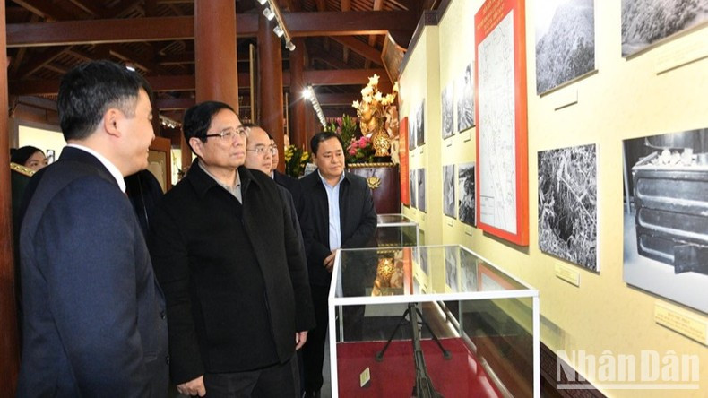 Премьер-министр Фам Минь Тьинь рассматривает документы и артефакты, выставленные в мемориальном доме Президента Хо Ши Мина. Фото: Тхань Жанг