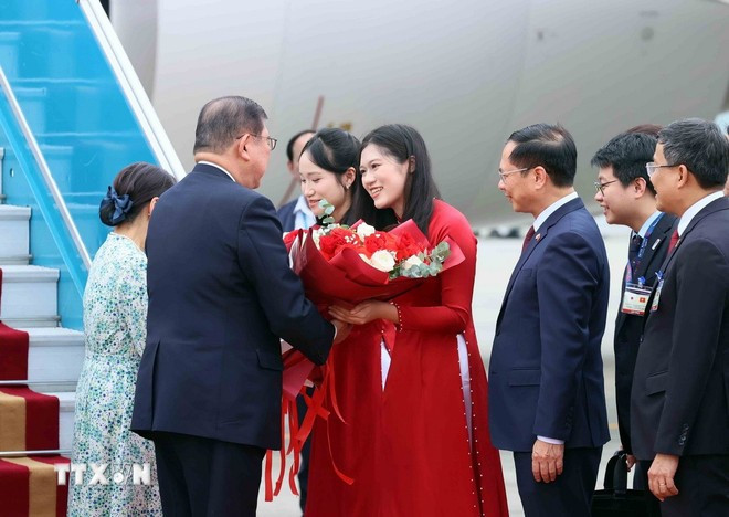 Ханойские девушки дарят цветы, приветствуя Премьер-министра Японии Исибы Сигэру и его супругу. Фото: ВИА