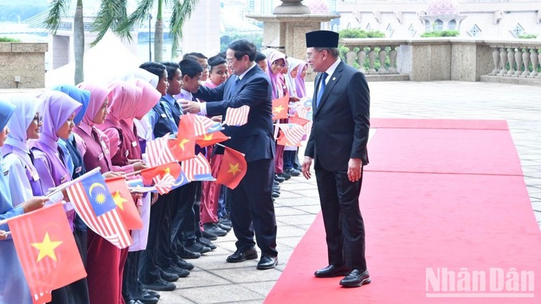 Премьер-министр Фам Минь Тьинь с малайзийскими школьниками. Фото: Тхань Жанг