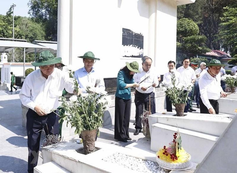 Президент Нгуен Суан Фук воскуряет благовония и возлагает цветы в память о 10 павших молодых добровольцах-женщинах. Фото: VNA