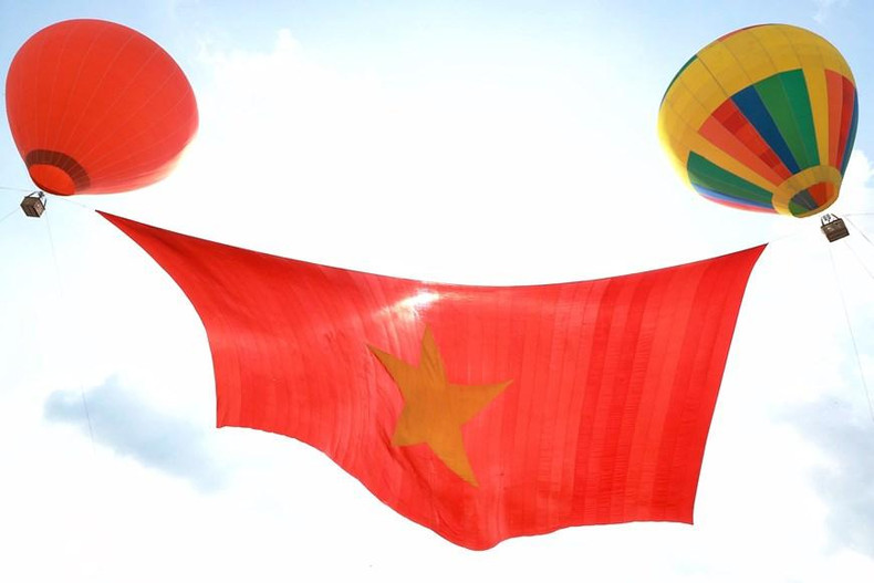 Флаг был поднят в небо двумя воздушными шарами. Фото: VNA Флаг был поднят в небо двумя воздушными шарами. Фото: VNA
