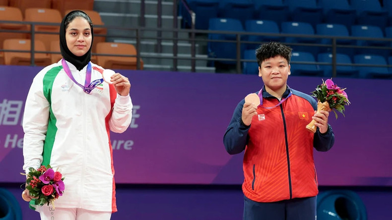 Спортсменка по курашу Фыонг Куинь (справа) получает бронзовую медаль. Спортсменка по курашу Фыонг Куинь (справа) получает бронзовую медаль.