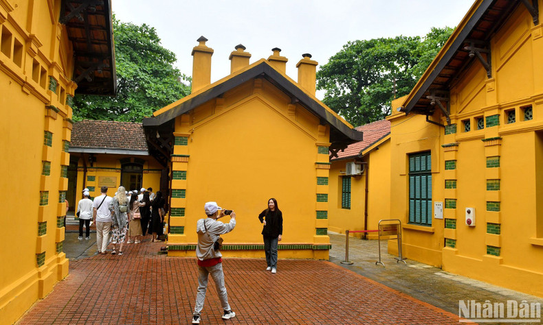 Туристы посещают ряды желтых домов с уникальной архитектурой в Мемориальном комплексе. Туристы посещают ряды желтых домов с уникальной архитектурой в Мемориальном комплексе.