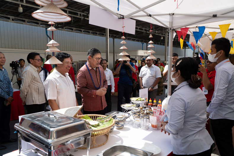 Посол Вьетнама в Камбодже Нгуен Хюи Танг (в белой рубашке) представляет Вице-премьеру, Министру иностранных дел и международного сотрудничества Камбоджи Сок Ченда Софеа стенд вьетнамской кухни. Фото: Нгуен Хиеп