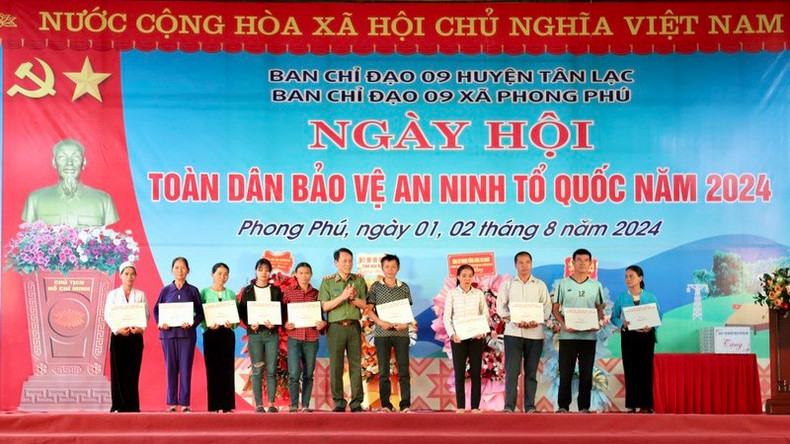 Министр Лыонг Там Куанг вручает похвальные грамоты коллективам и отдельным лицам, добившимся выдающихся результатов в движении всенародной защиты безопасности Отечества, в провинции Хоабинь.