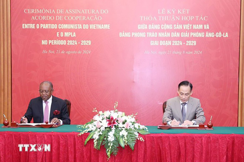Товарищ Ле Хоай Чунг и товарищ Мануэл Домингуш Аугусто подписывают соглашение о сотрудничестве между КПВ и МПЛА. Фото: ВИА