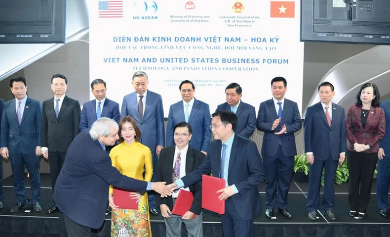 Премьер-министр Фам Минь Тьинь и делегаты на церемонии подписания документов о сотрудничестве между предприятиями двух стран.