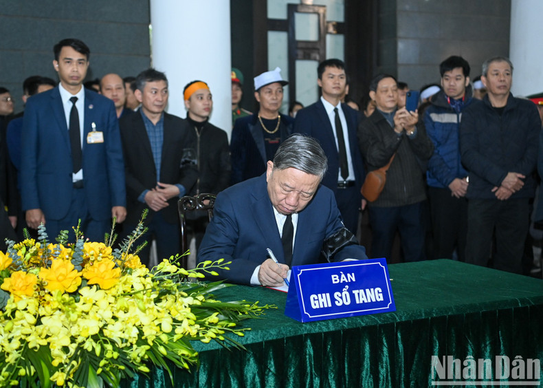 Генеральный секретарь ЦК КПВ То Лам оставляет запись в траурной книге.