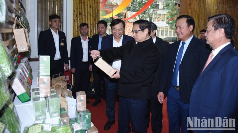 Премьер-министр Фам Минь Тьинь посещает стенд, на котором представлена типичная продукция OCOP. Фото: Чан Хай