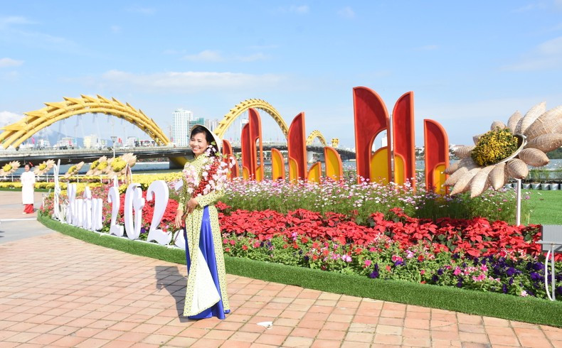 Вьетнамская посетительница фотографируется на цветочной улице. Вьетнамская посетительница фотографируется на цветочной улице.