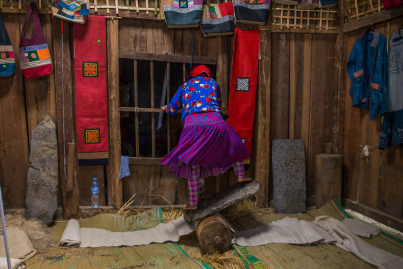 Готовая ткань помещается между каменной плитой и деревянным столбом. Камень катают взад и вперед, пока вся поверхность ткани не станет плоской, мягкой и гладкой, прежде чем ее пропитают древесной золой в течение недели до белого цвета, а затем высушивают. Готовая ткань помещается между каменной плитой и деревянным столбом. Камень катают взад и вперед, пока вся поверхность ткани не станет плоской, мягкой и гладкой, прежде чем ее пропитают древесной золой в течение недели до белого цвета, а затем высушивают.