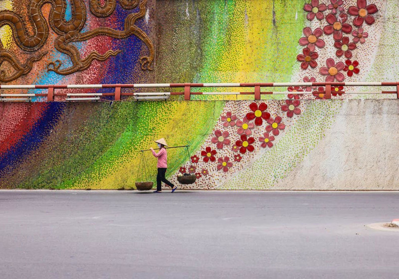 Фотография лоточницы, идущей по керамической улице в Ханое, была опубликована в июле 2022 года.