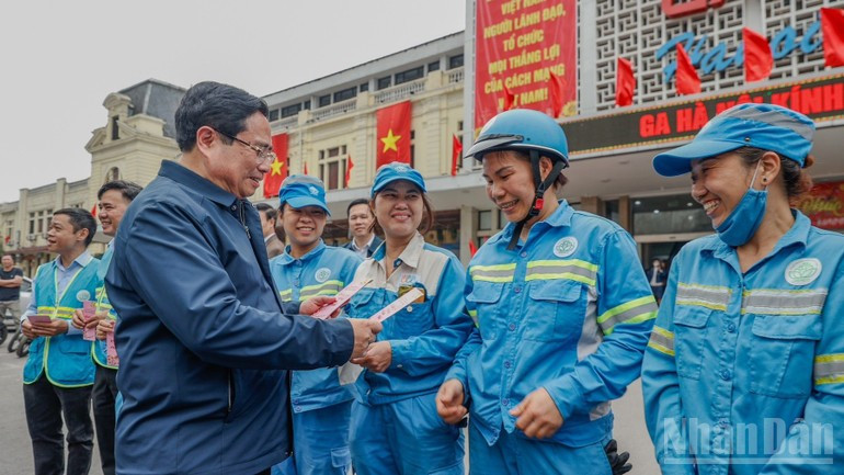 Премьер-министр Фам Минь Тьинь вручает подарки и поздравляет с праздником работников санитарной службы, дежурящих на вокзале Ханоя.