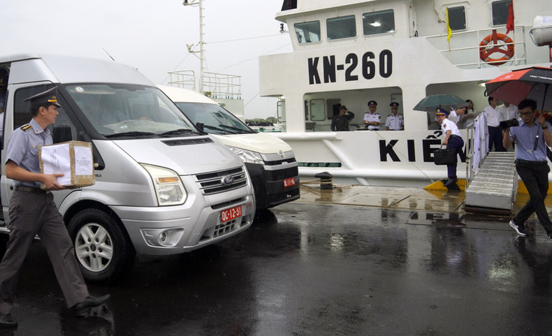 Член избирательной комиссии поднимает урну для голосования на борт судна KN 260, направлявшегося в суверенные воды страны для проведения голосования.